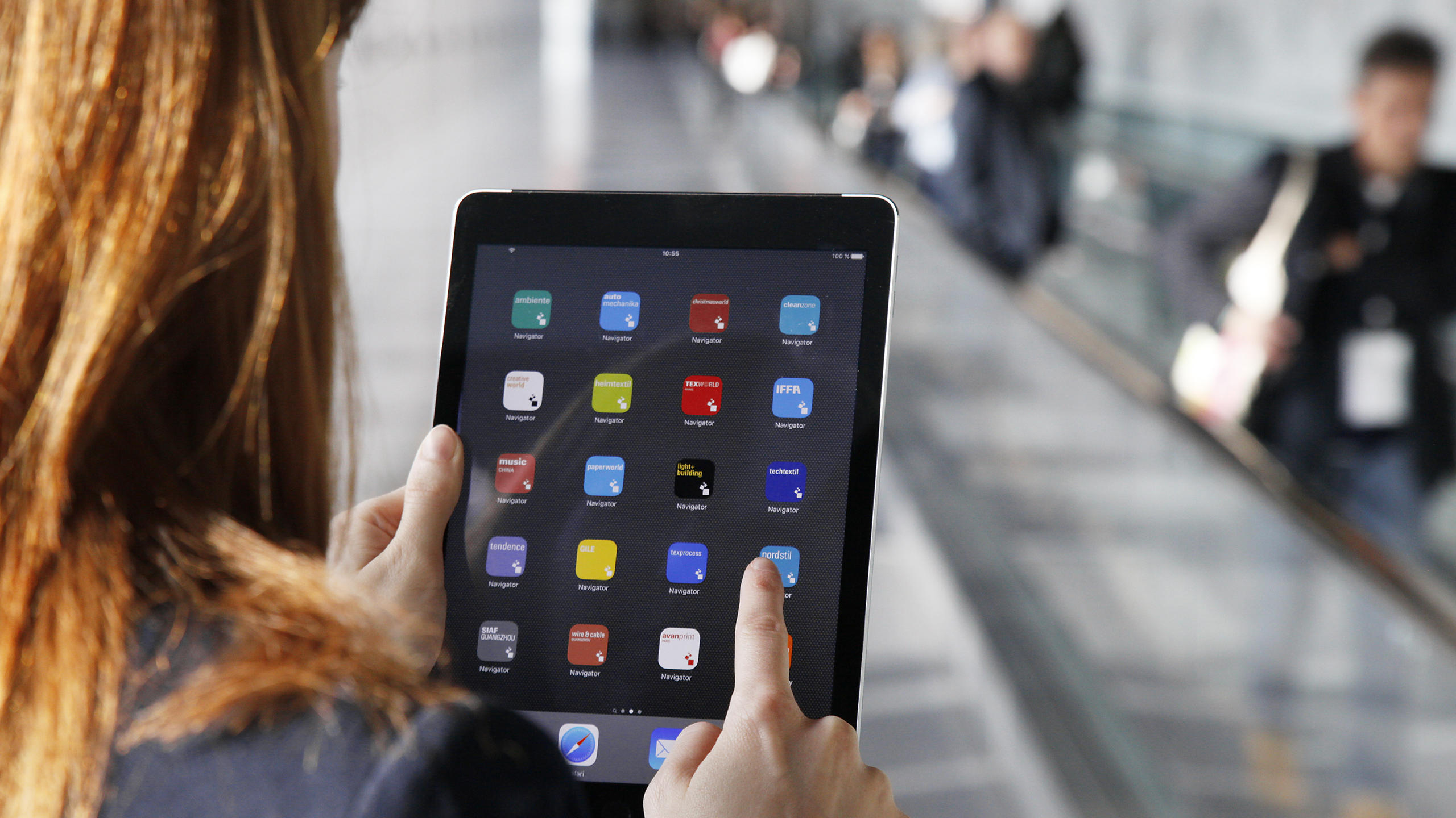 Frau klickt auf eine Messe Frankfurt App auf einem Tablet